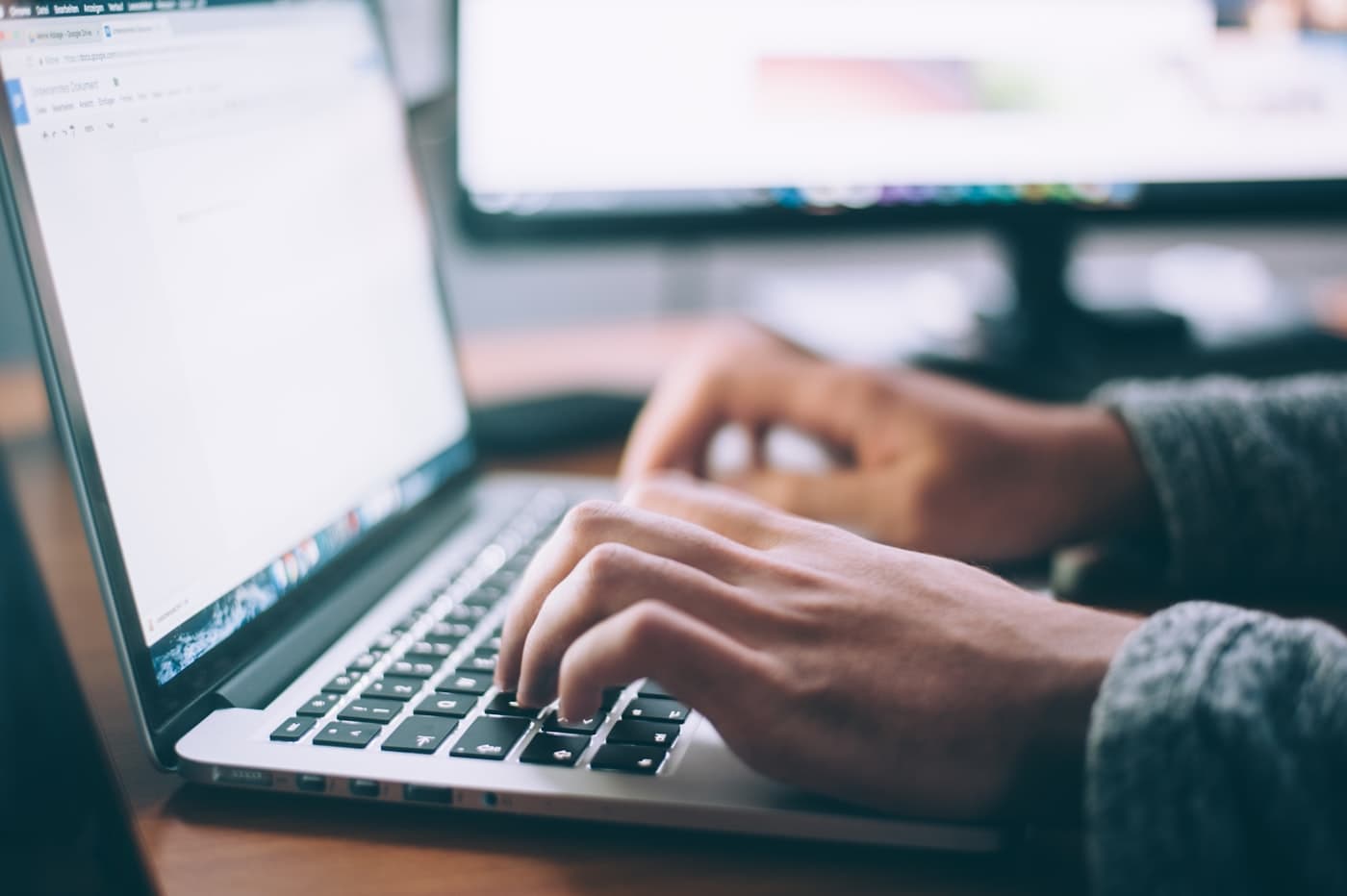Handen typen een e-mail op een laptop