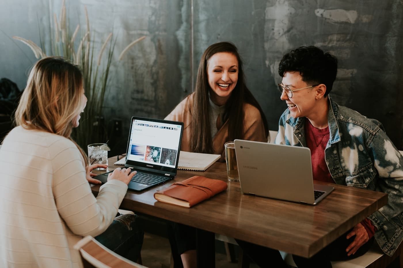 Jonge mensen helpen elkaar met laptops aan tafel